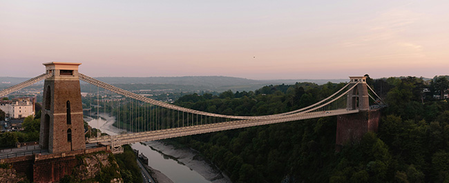 clifton suspension bridge in front of a pink sunset