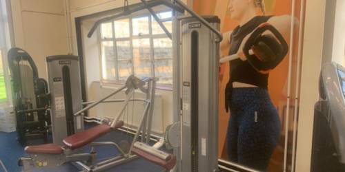 3 different weight machines positioned in front of a window.