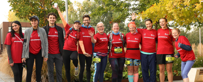 A diverse group of adults standing in a row in red 