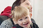 Carer and small child hugging and laughing
