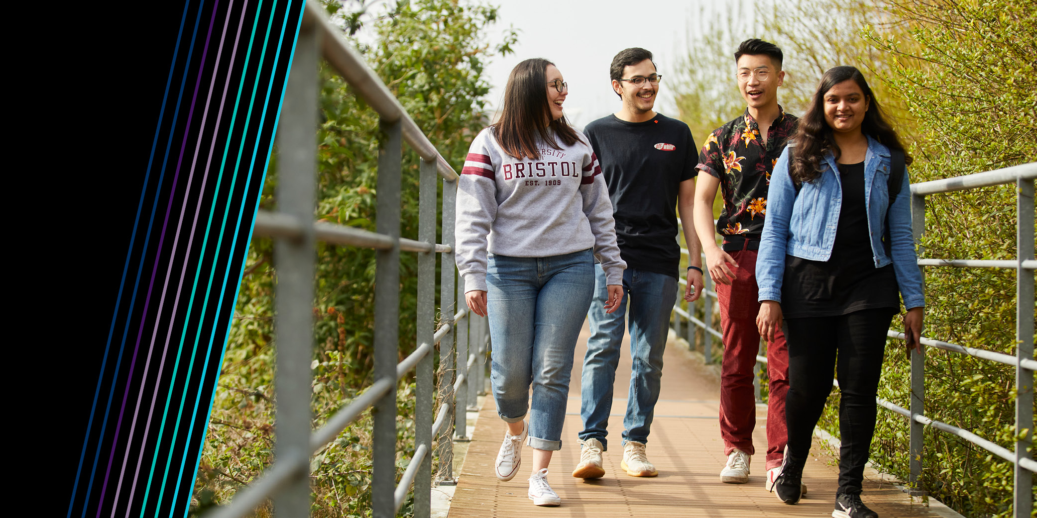 Four students walking along Bristol harbourside