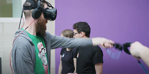 Student with a VR headset on and hand-held device