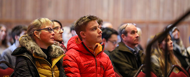 A student and their parent/carer listen to a talk being held in the historic Great Hall of Wills Memorial Building