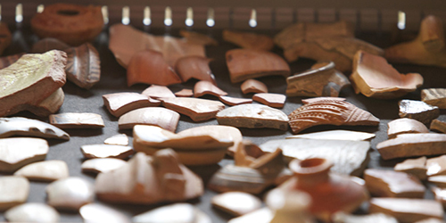 Pieces of ancient pottery laid out on a table.