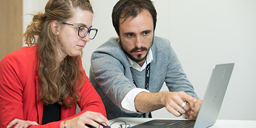 Two people working together on a laptop.