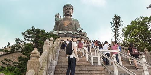 Lots of people climbing the stairs up towards The Big Buddha statue in Hong Kong.