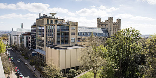 The exterior of a large building with lots of windows on a sunny day.