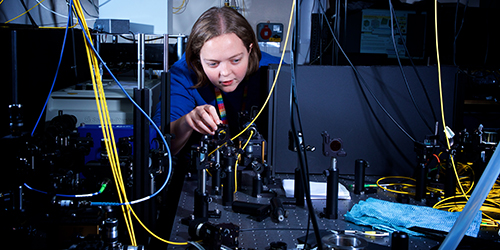 A person placing wires into an electrical board.