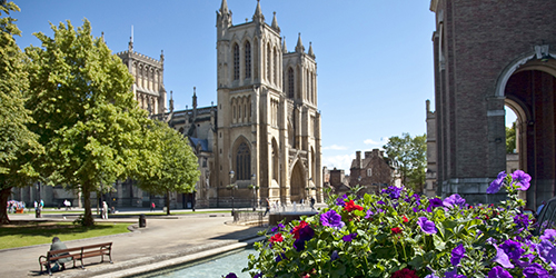 A cathedral on a sunny day with flowers in the foreground.