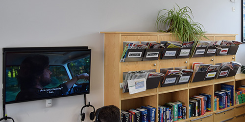A bookcase and television screen with audio equipment.