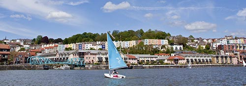 A small sailing dinghy on Bristol Harbour on a sunny day 