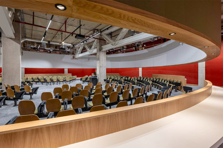 A circular lecture theatre, with seats facing a central point, enclosed in a wooden circular structure.