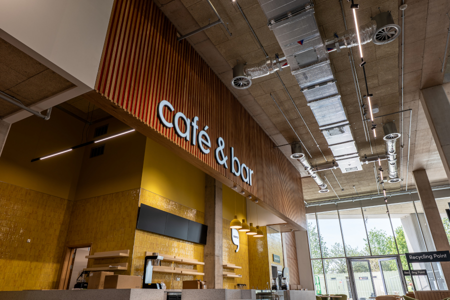 An industrial space with a cafe counter, with a bright yellow titled interior.