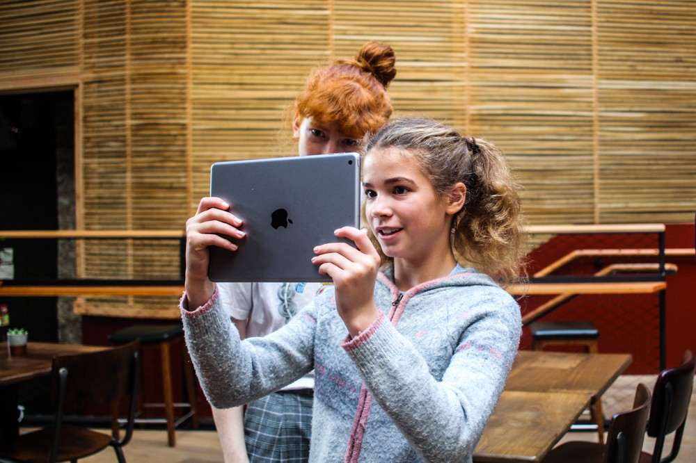 Two young people look at virtual content on an iPad