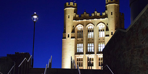 Historic university building lit up at night. 