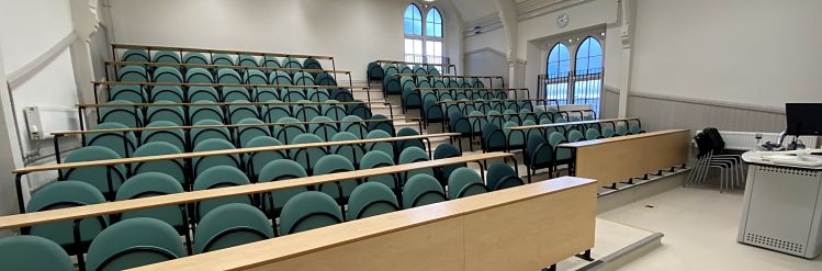 A lecture theatre with green chairs