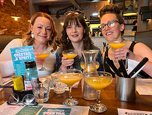 three ladies drinking cocktails